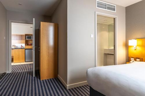a hotel room with a bed and a kitchen at Ramada Hotel & Suites by Wyndham Coventry in Coventry