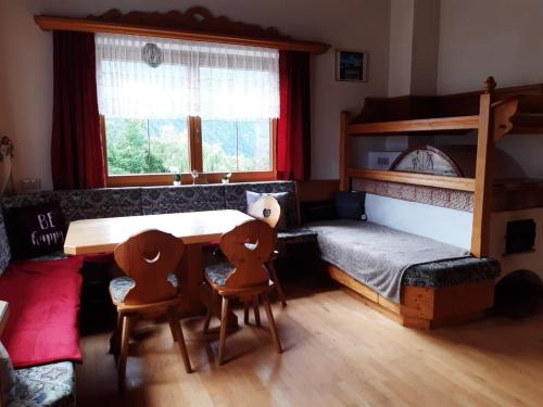 Ferienhaus Kuenzerhof في Klaunz: غرفة نوم مع طاولة وكراسي وسرير بطابقين