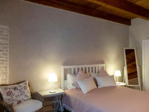a bedroom with a bed with two lamps and a chair at Az. Agr. Parco dei Buoi in Larino