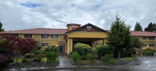a large yellow building with a lot of plants at Best Western Plus Parkway Inn in Wilsonville
