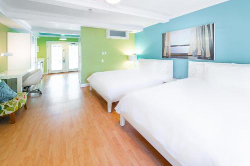a hotel room with two beds and a desk at Canalside Inn in Rehoboth Beach