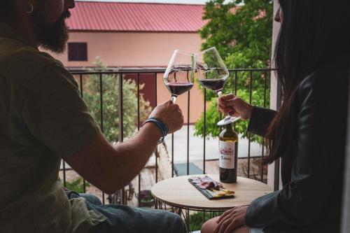 Quintanilla de ArribaにあるHotel rural La Tejeraのワインをテーブルに持ち上げて2人