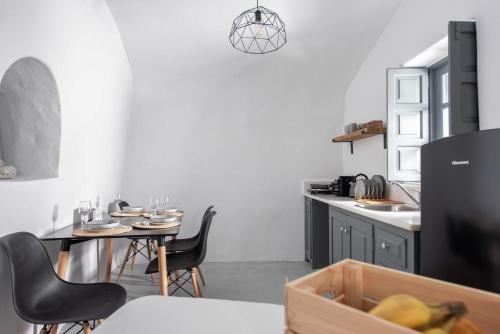 a kitchen with a table and chairs and a table at Noelia Suites in Oia