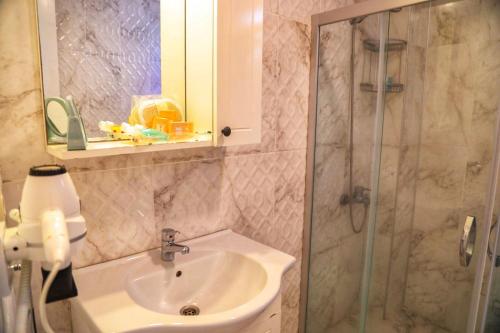 a bathroom with a sink and a shower at Sari Gelin Alacati Hotel in Alacati