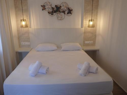 a white bed with two towels on top of it at Naxos Illusion Nikos Verikokos in Naxos Chora