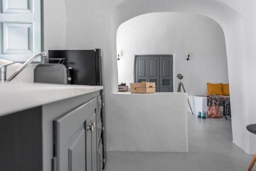 a kitchen with a counter and a black refrigerator at Noelia Suites in Oia