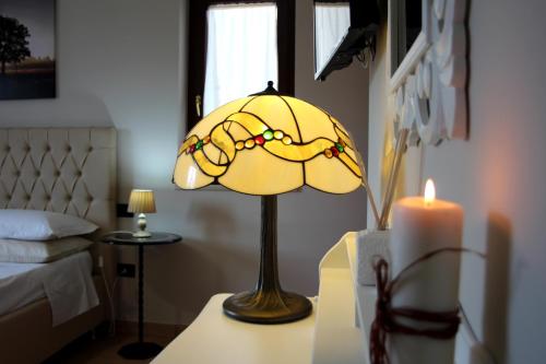 una lámpara en una mesa en un dormitorio con una vela en B&B Atrium, en Pompeya