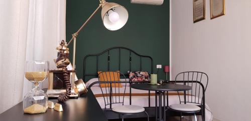 Habitación con mesa, sillas y pared verde. en Villa Noemi Bed&Breakfast en Pisa