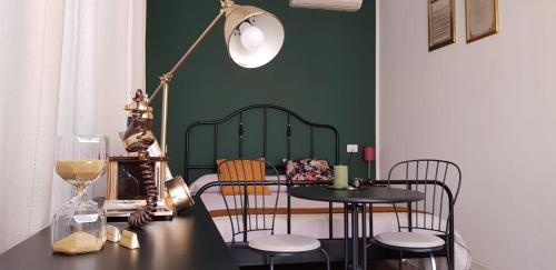 a room with a table and chairs and a green wall at Villa Noemi Bed&Breakfast in Pisa