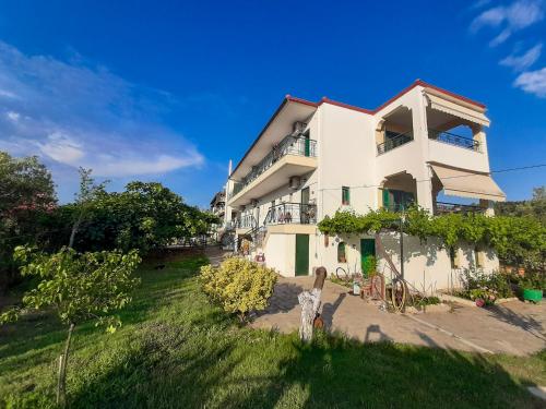 a white house with a yard in front of it at Sapfo Beach Studios in Nikiti