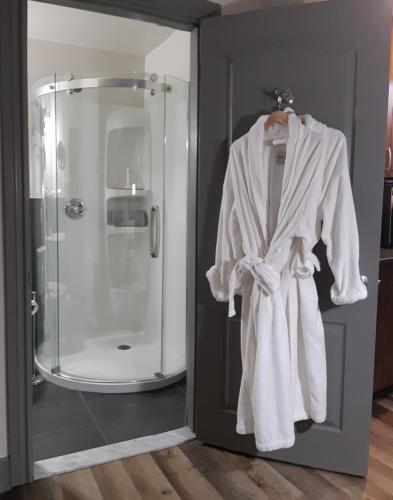 a robe hanging on a door in a bathroom at Oberge Inn Val-David in Val-David