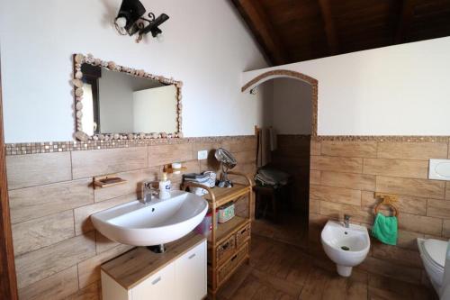 La salle de bains est pourvue d'un lavabo, d'un miroir et de toilettes. dans l'établissement Domo mea, à Porto Torres