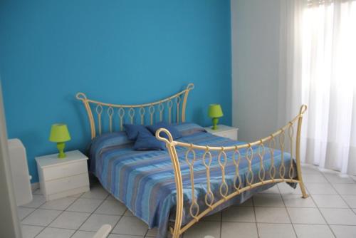 1 dormitorio con 1 cama con pared azul en Sottovento, en Marina di Modica