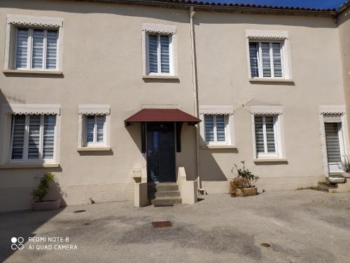 une maison blanche avec une porte et des escaliers noirs. dans l'établissement chambre meublée à louer, à Pouzauges