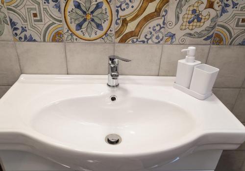 a white bathroom sink with a soap dispenser on it at Zeus Atabyrios - Locazione Turistica in Agrigento