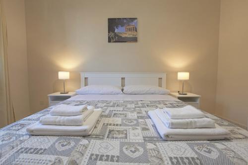 a bedroom with a large bed with three pillows on it at Zeus Atabyrios - Locazione Turistica in Agrigento