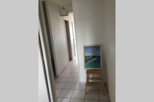 un tableau assis sur un stand dans un couloir dans l'établissement Appartement 7 rez de chaussée vue mer, à Guidel