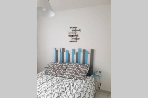 um quarto com uma cama com uma cabeceira azul em Appartement 7 rez de chaussée vue mer em Guidel