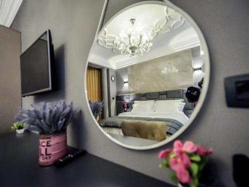1 dormitorio con cama y espejo en Hotel Vila Tirana, en Tirana
