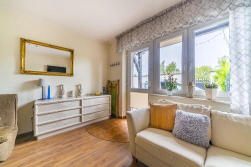 a living room with a couch and a window at Willa Michalinka in Jastarnia