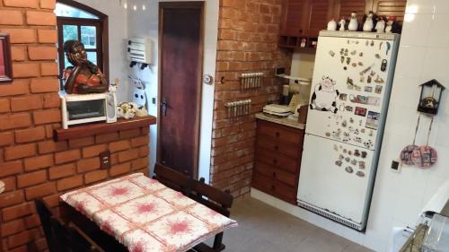 a kitchen with a brick wall and a refrigerator at Perto do Centro Histórico in Petrópolis