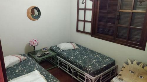 a room with two twin beds and a table at Perto do Centro Histórico in Petrópolis