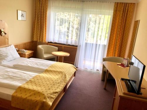 a hotel room with a bed and a window at Landhotel Moorhof in Franking