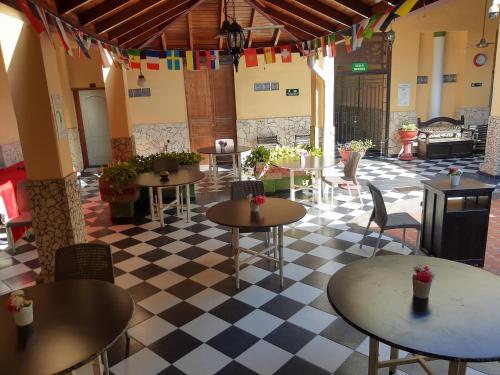 a restaurant with tables and chairs on a checkered floor at Hotel Bahia Blanca Santa Marta Frente al Mar in Santa Marta