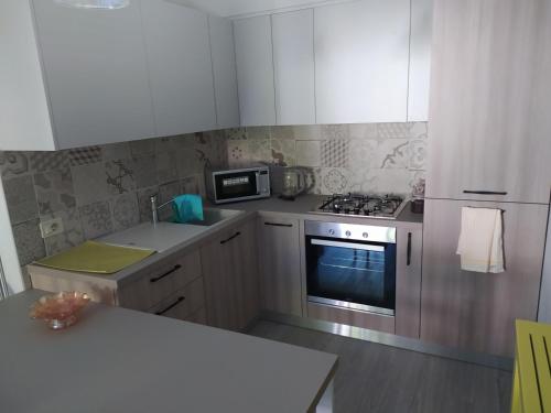 a kitchen with white cabinets and a stove top oven at Alex's home 2 in Crone