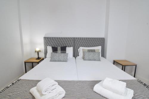um quarto com uma grande cama branca e 2 almofadas em Letmalaga Premium Malagueta em Málaga