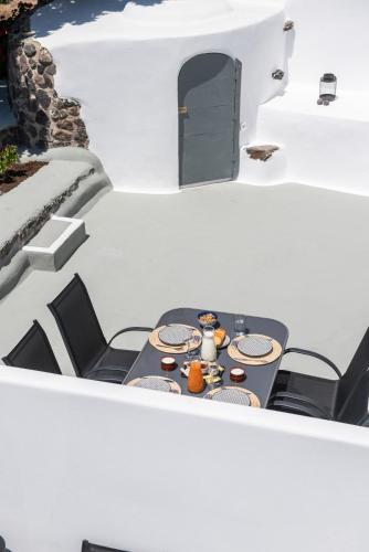 a table and chairs on the side of a house at Noelia Suites in Oia