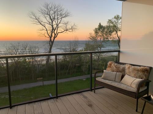 a couch on a balcony with a view of the ocean at Seaside Park apartamenty prywatne z widokiem na morze in Kołobrzeg
