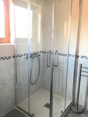 a shower with glass doors in a bathroom at Casa da Barriada I in Bragança