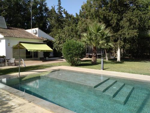 uma piscina no quintal de uma casa em Chalet con Piscina - LAS ADELFAS em Chiclana de la Frontera