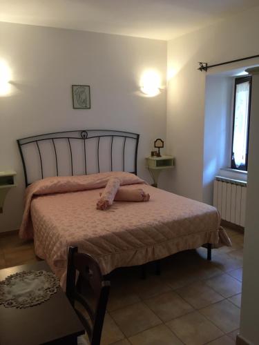 1 dormitorio con 1 cama con colcha rosa en Albergo Andromeda en Pescasseroli