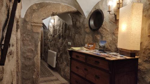 a bathroom with a wooden dresser in a stone wall at Apartamentos Rurales La Casa de Luis in Santa Cruz de la Sierra