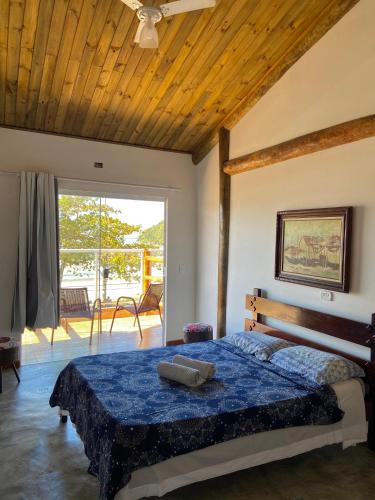 a bedroom with a bed with a wooden ceiling at Chales Marissol in Ubatuba