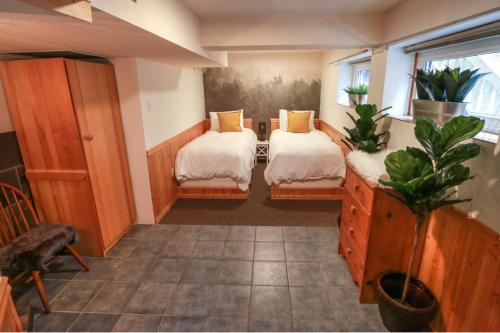 a room with two beds and a table with a plant at Banff's Enchanted Forest Basement Suite in Banff