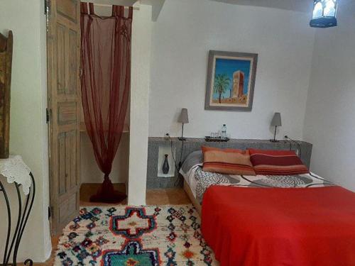 a bedroom with a bed with a red blanket at Au Bord de l'Eau in Setti Fatma