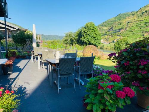a patio with a table and chairs and flowers at Weinbergs Loge in Ernst