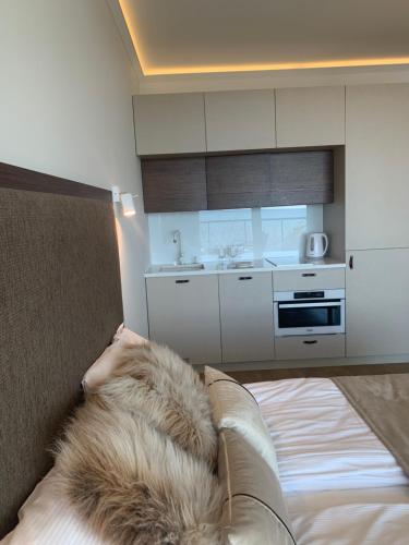 a person laying on a bed in a kitchen at Seaside Park apartamenty prywatne z widokiem na morze in Kołobrzeg
