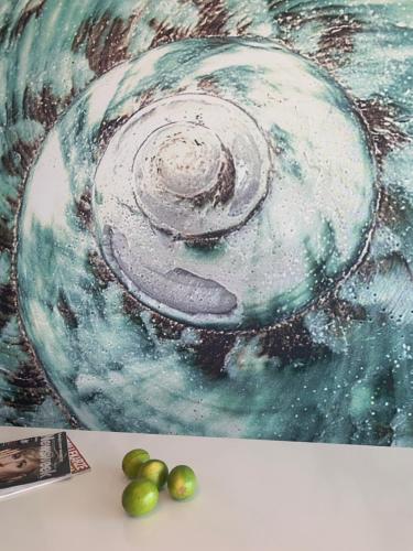 a painting and some green fruit on a table at Seaside Park apartamenty prywatne z widokiem na morze in Kołobrzeg