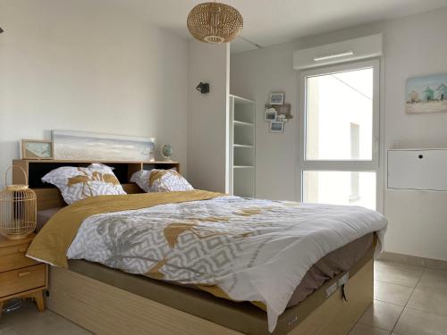 a bedroom with a large bed and a window at Le petit paradis de Valentin in Argelès-sur-Mer