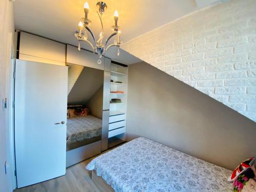 a bedroom with a bed and a brick wall at Dviejų kambarių butas in Palanga