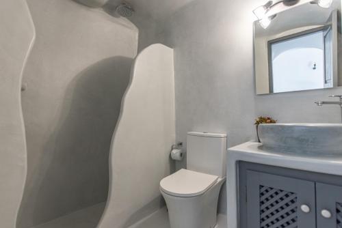 a bathroom with a toilet and a sink at Noelia Suites in Oia