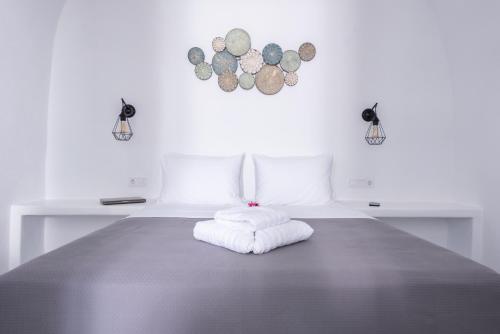 a white bed with a white pillow on it at Noelia Suites in Oia