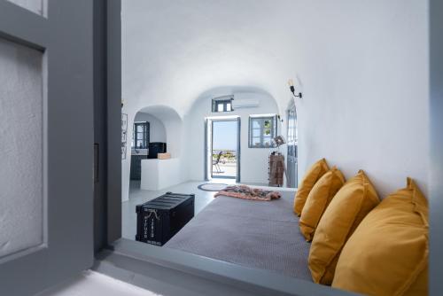a living room with a couch with yellow pillows at Noelia Suites in Oia