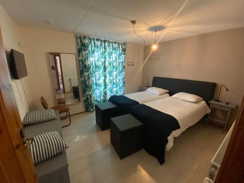 ein Schlafzimmer mit einem großen Bett mit einem blauen Vorhang in der Unterkunft Hotel Restaurant de Boekanier in Vrouwenpolder