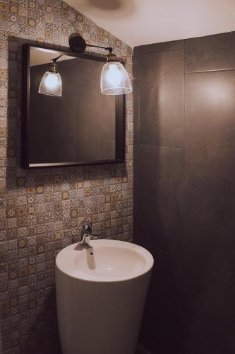 a bathroom with a white sink and a mirror at The Hygge House in Plopi