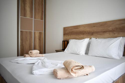 a bedroom with a bed with towels on it at Lux Kalimera Apartments in Ulcinj